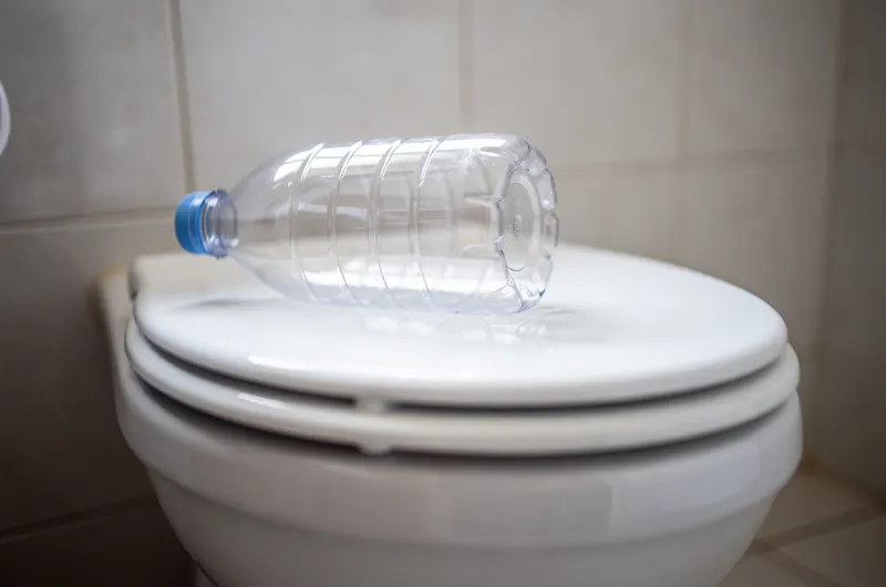 Garrafa PET cortada sobre o vaso sanitário